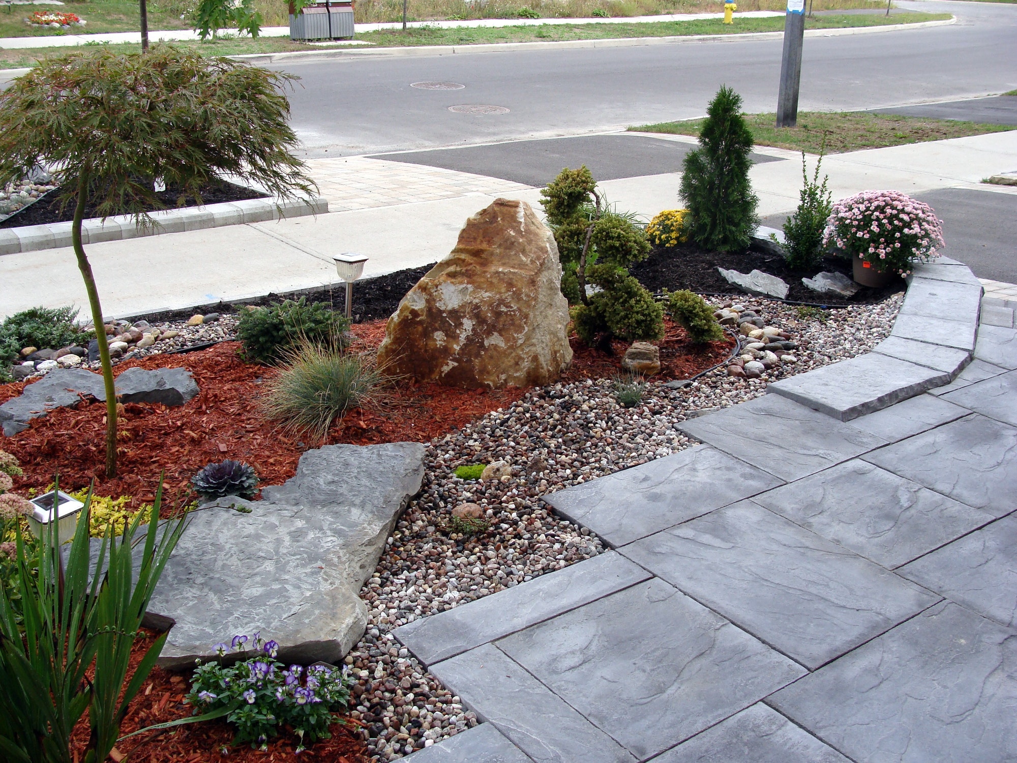 Landscaping project in front of the house, rock garden, travertine tiles, planting evergreens design